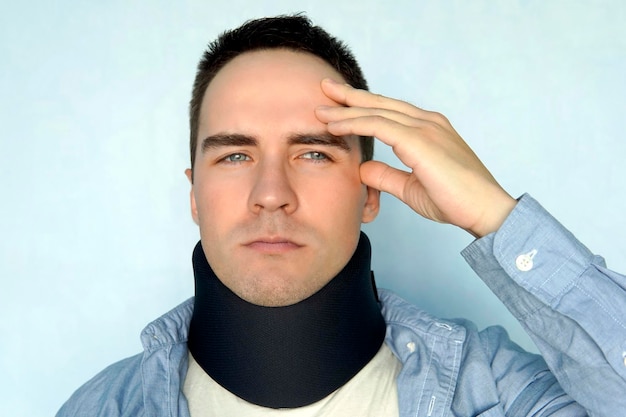 A guy with a bad neck in a black neck collar to stabilize the cervical vertebrae A man with a neck injury spinal fracture headache