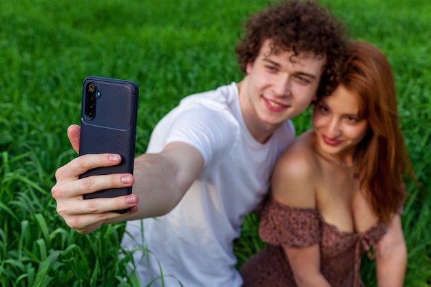 A guy with a girl take a selfie on the phone