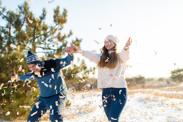 The guy with the girl throw confetti in the winter forest