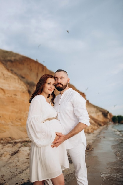 A guy with a girl in white clothes on the seashore