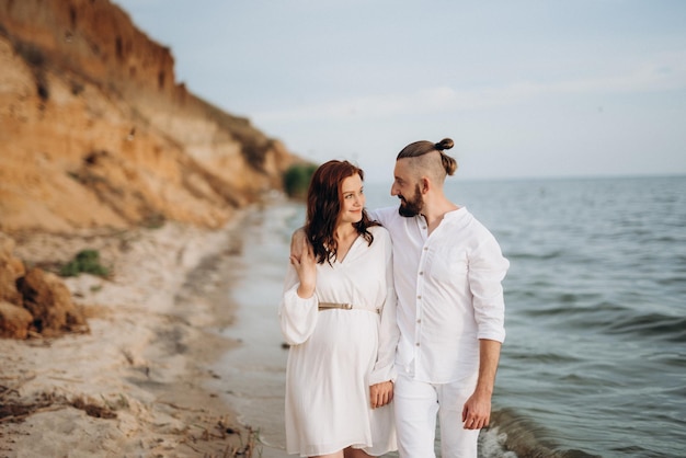 A guy with a girl in white clothes on the seashore