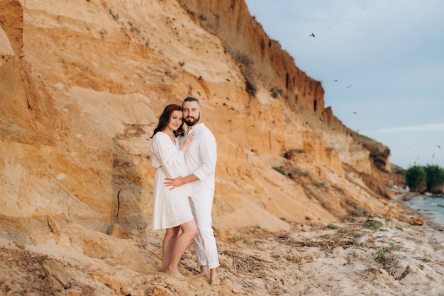 A guy with a girl in white clothes on the seashore