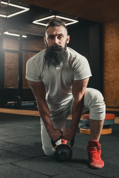 Gym. Bearded man training.