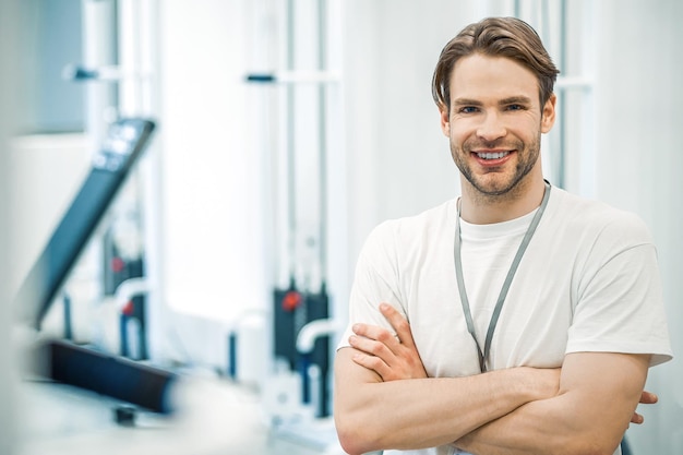 In a gym Young man in sportswear sitting on a training device in a gym