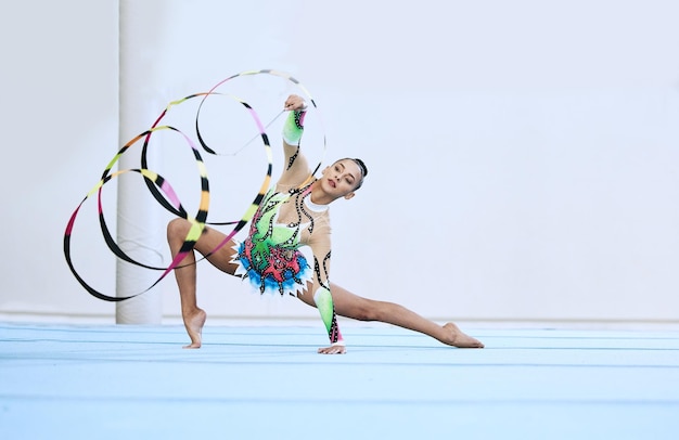 Gymnastics woman ribbon and floor in portrait competition or sport for fitness performance or studio Gymnast athlete girl and professional dancer with balance exercise or contest for creativity