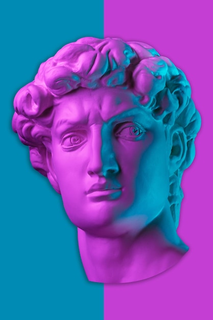 Gypsum copy of head statue david in bright neon colors for artists on a color background face famous