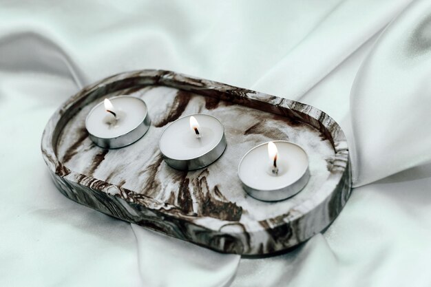 Gypsum marble decorative stand with candles on the background of silk stand