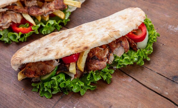 Gyros shawarma take away street food Sandwich with meat on wooden table