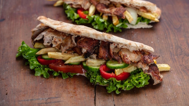 Gyros shawarma take away street food Sandwich with meat on wooden table