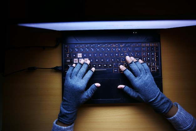 Hacker hand stealing data from laptop top down