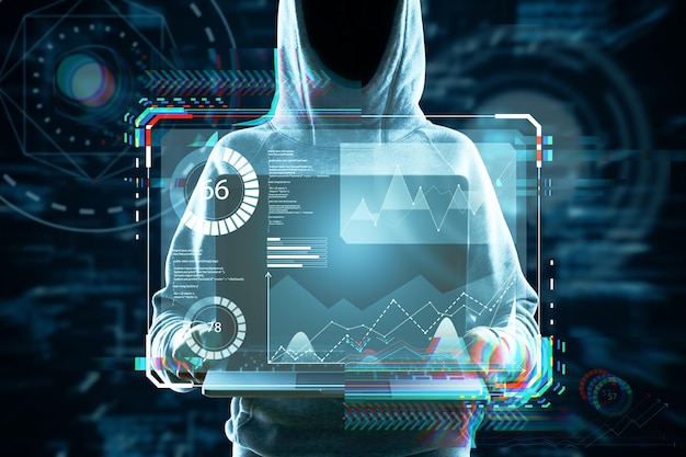 Hacker holding laptop with abstract glowing business hologram interface on dark background Security hacking autorization and biometrics concept Double exposure