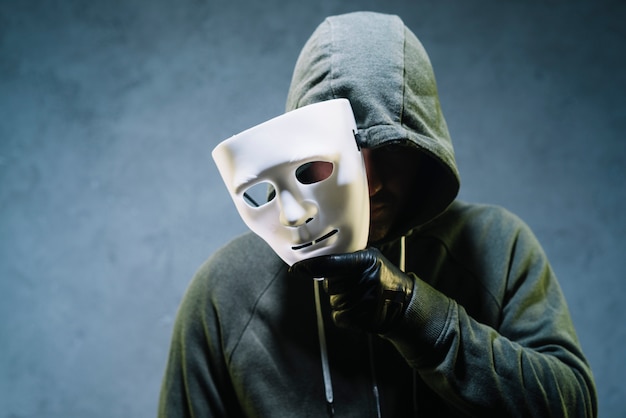 Hacker holding mask