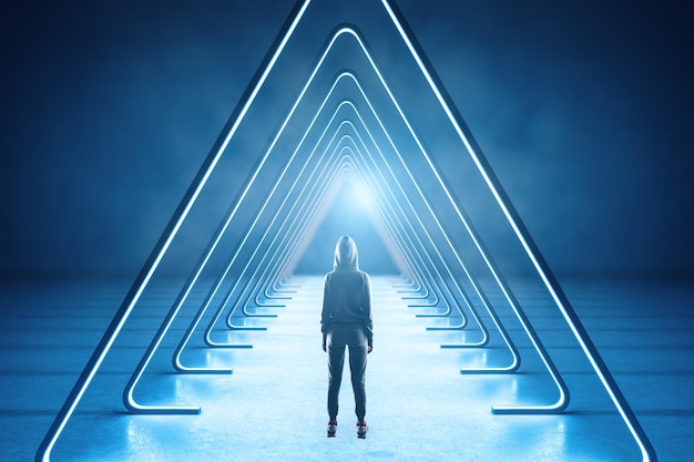 Hacker standing in interior with luminous triangle corridor