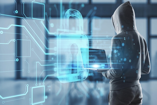 Hacker using laptop in interior with abstract glowing padlock hologram on blurry office background Secure hacking safety and web protection concept Double exposure