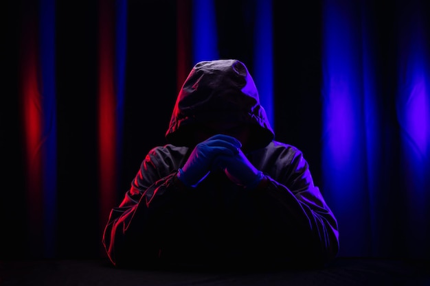 Hackers wear hoods to cover their faces. Hacking to steal important information. Use a computer to release malware viruses Ransom and harass organizations. He sitting in the dark room with neon light