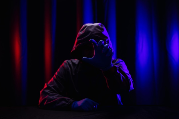 Hackers wear hoods to cover their faces. Hacking to steal important information. Use a computer to release malware viruses Ransom and harass organizations. He sitting in the dark room with neon light