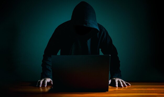 Hackers work on laptops in the dark The concept of information security in the Internet network and information espionage