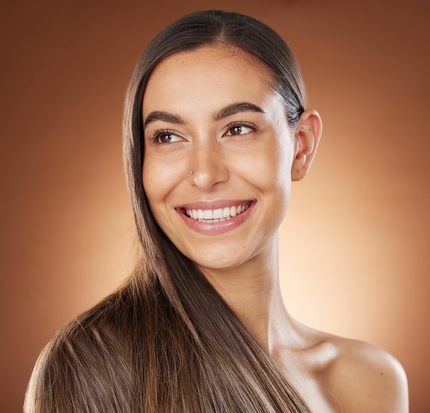 Hair beauty and skincare with a model woman in studio on a brown background for natural or keratin treatment Face haircare and salon with an attractive young female posing to promote a product