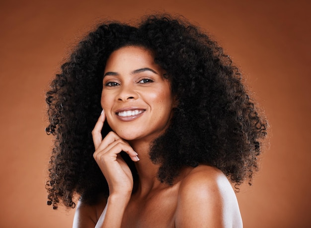 Hair care beauty and portrait of black woman with afro on brown background in studio for wellness Beauty cosmetics and happy female model with glowing skin healthy and natural curly hairstyle