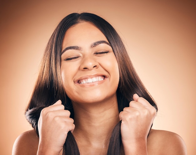 Hair care smile and woman with strong texture eyes closed and isolated in studio on a brown background Hairstyle natural cosmetic and model with salon treatment for beauty health or aesthetic