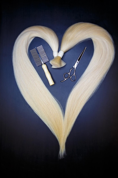 Hair extension equipment of natural blonde hair heart shape on a dark background