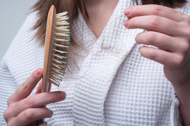 Hair loss in women young woman is upset because of hair loss problem hair in comb