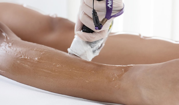 Hair removal cosmetology procedure from a therapist at cosmetic beauty spa clinic. Laser epilation.