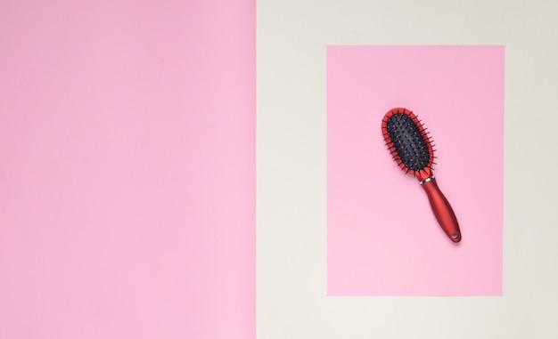 Hairbrush on a pink pastel surface. Minimalism. Top View