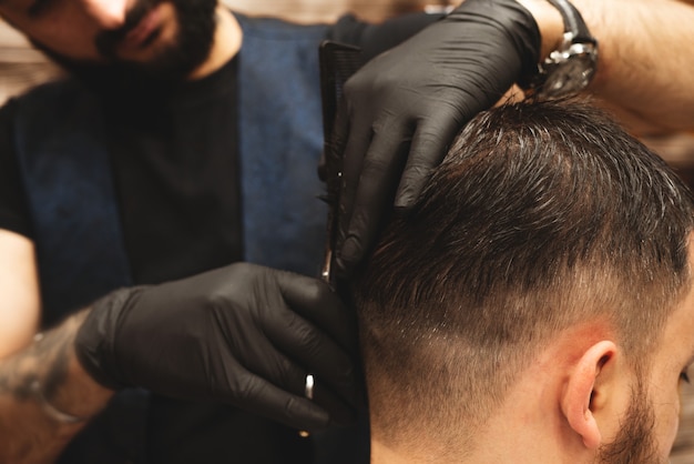 Haircut head in barbershop, Barber cuts the hair on the head of the client. 