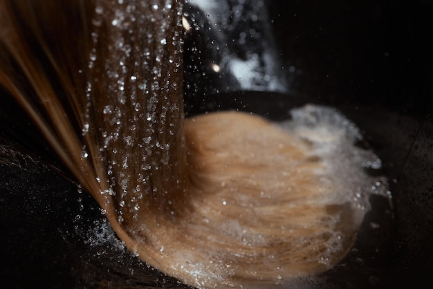 Hairdresser in beauty salon washes his client hair, before procedure of applying natural restoring ingredients and vitamins to hair and haircut.