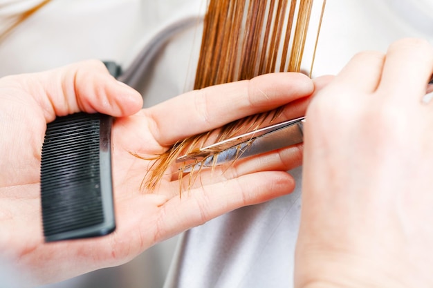 Hairdresser cutting the hair of a blonde woman