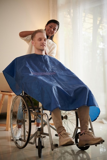 Hairdresser Cutting Hair of Man with Disability