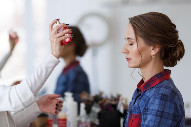 Hairdresser hands  with bootle hair spray in hands beauty concept process of hair styling in salon