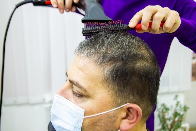 hairdresser is cutting clients hair in barber shop