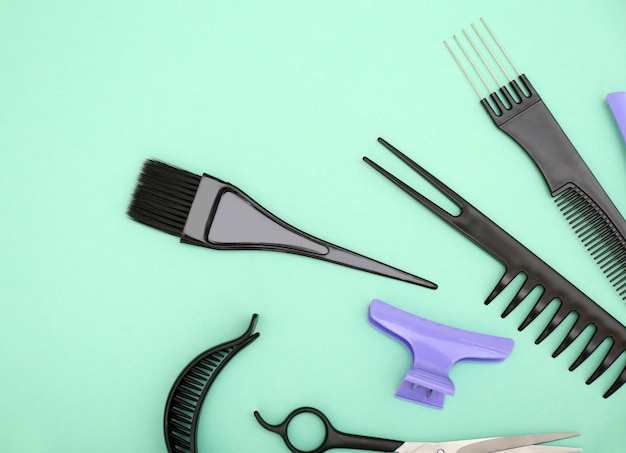 Hairdresser set with various accessories on turquoise background