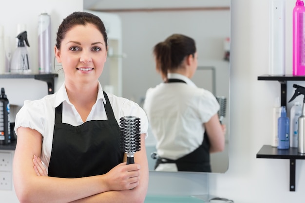 Hairdresser with hair brush in hairdressing salon