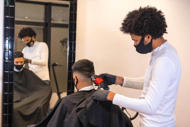 Hairdresser with mask and gloves cutting hair Security measures