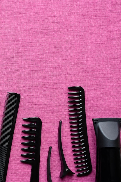 Hairdressing tools on pink background and space for text