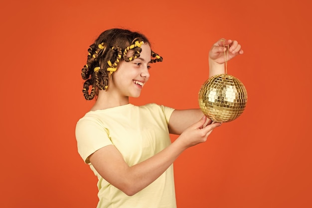 Hairstyle for disco party Have fun Retro party Child hold golden disco ball Cheerful girl with disco ball Fashion kid posing with curlers in hair Night club Hairdresser salon Fancy teen