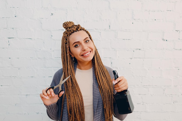 Hairstylist braided afro braids pigtails hair of female client in barber salon