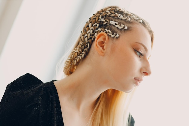 Hairstylist braided afro braids pigtails hair of female client in barber salon