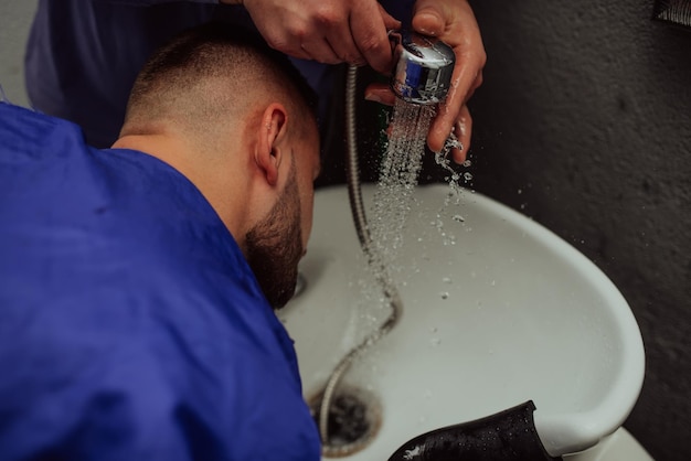 Hairstylist washing client39s bears in a barbershop Selective focus High quality photo