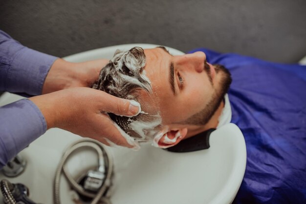 Hairstylist washing client39s hair in a barber shop Selective focus High quality photo