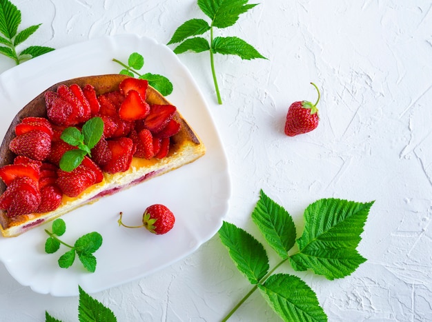 Half cheesecake with fresh strawberries 