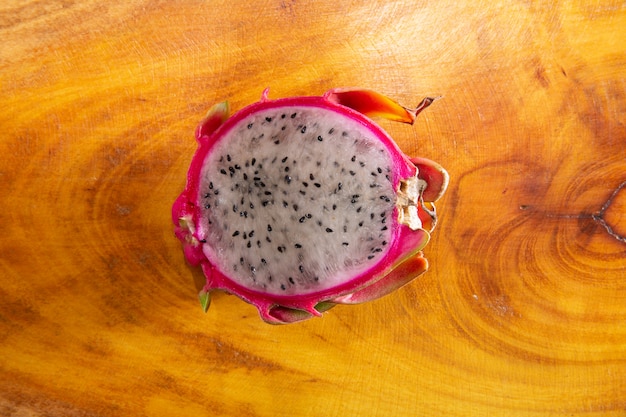 Half of dragon fruit on rustic wooden background. Pitaya or Dragon Fruit. Exotic tropical fruit.