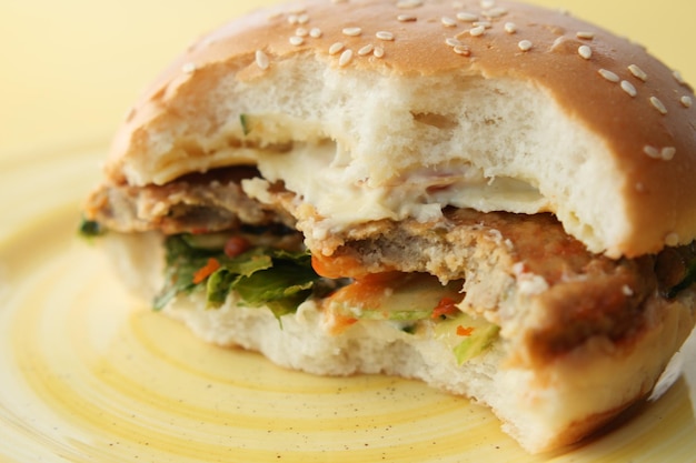 Half eaten beef burger on table close up