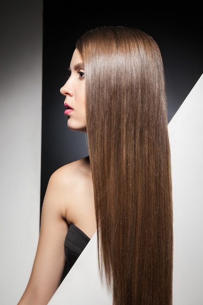 Half face of attractive young brunette with long shining hair