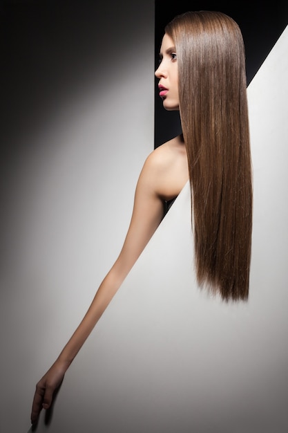 Half face of attractive young brunette with long shining hair