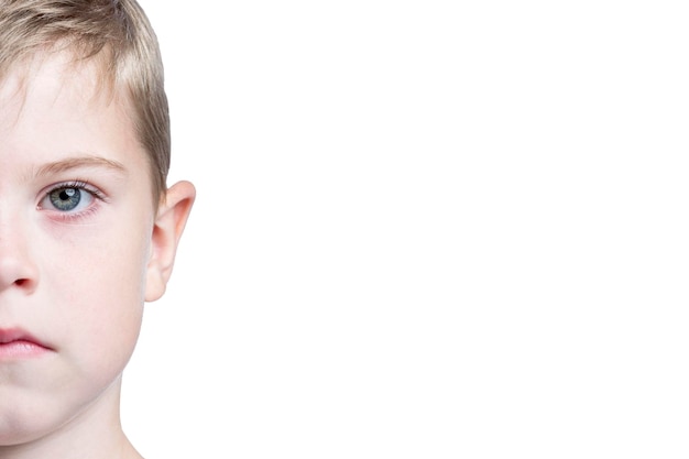 Half face of a serious boy Closeup Isolated on white background Space for text