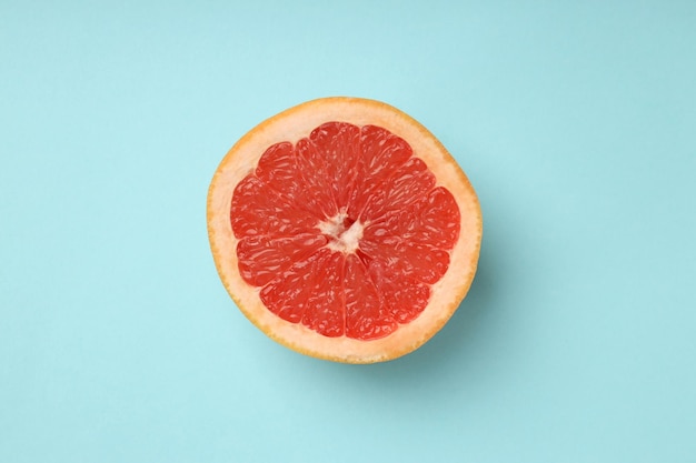 Half of grapefruit on blue background top view